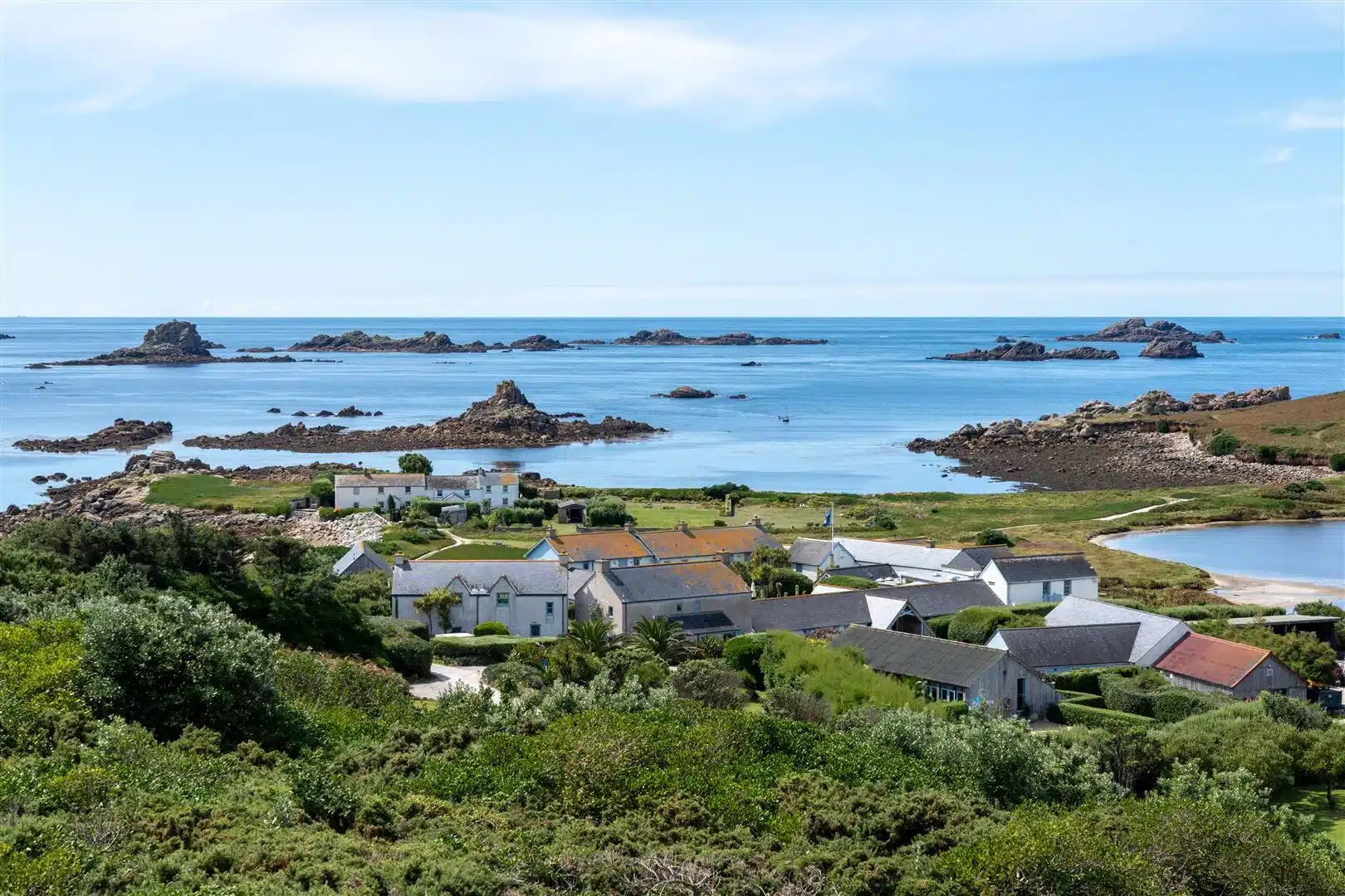 Aerial image of Hell Bay Hotel in the foreground with blue ocean and rocks in the background